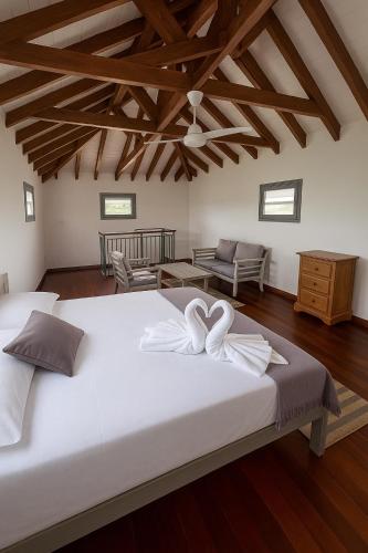 1 dormitorio con 1 cama blanca grande y 2 toallas blancas en Villa Ti Flè, en Saint-François