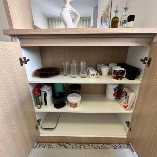 a cupboard with glasses and other items on it at Plano 22 Prime Loft in Extrema