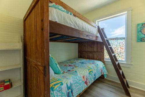 een stapelbed in een kleine kamer met een raam bij Crow's Nest K0380 in Nags Head