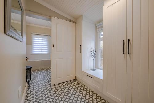 a bathroom with a white door and a window at Blue Bell in Hermanus