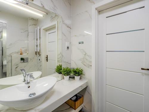 a white bathroom with a sink and a mirror at Apartament Królewski w centrum Nad Łomnicą 15 in Karpacz