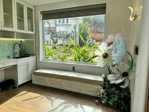 a window seat in a kitchen with a large window with flowers at Tiên Hoa Sơn Villa in Da Lat