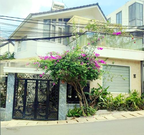 a house with a black gate and pink flowers at Tiên Hoa Sơn Villa in Da Lat