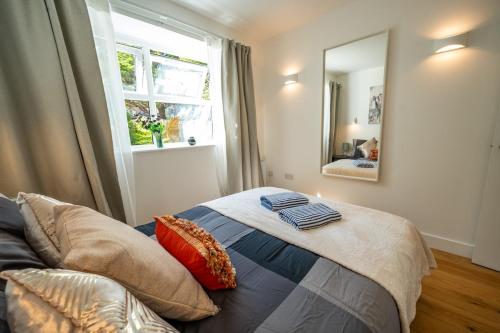 a bedroom with a bed with a mirror and a window at Beach Getaway in Eastbourne