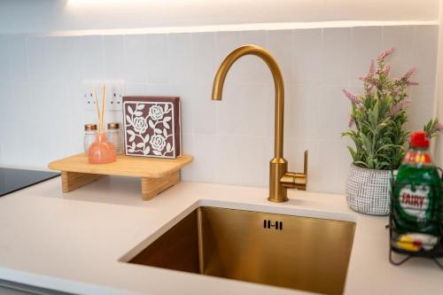 a kitchen sink with a gold faucet at Beach Getaway in Eastbourne