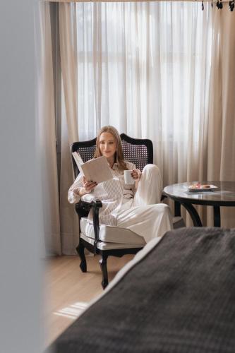 a woman sitting in a chair with a laptop at Hotel Casacurta in Garibaldi