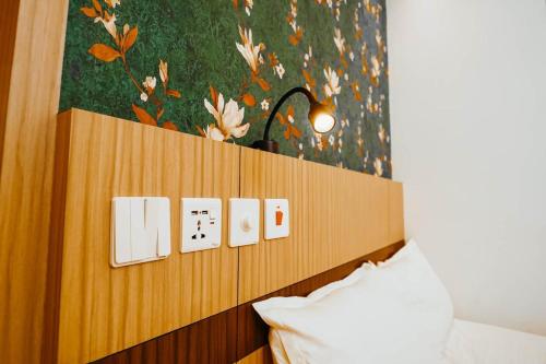 a bedroom with a bed and a wall with switches at Dubai Frame Residency And Hotel in Thottada
