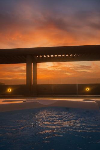 a bridge over a body of water at sunset at Distrito 90 luxury suites in Barranquilla