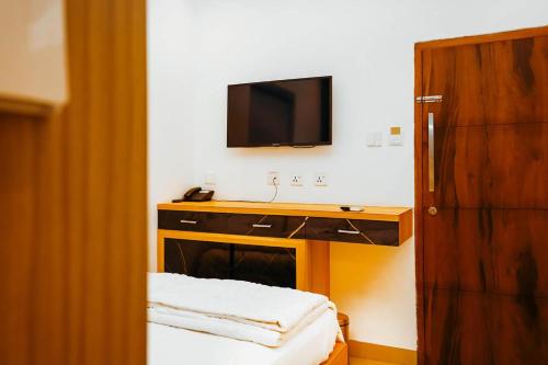 a bathroom with a sink and a tv on a wall at Dubai Frame Residency And Hotel in Thottada
