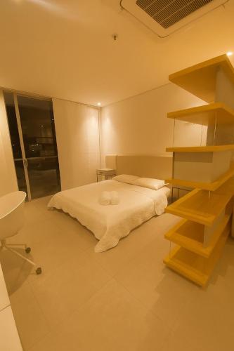 a bedroom with a bed and a book shelf at Distrito 90 luxury suites in Barranquilla