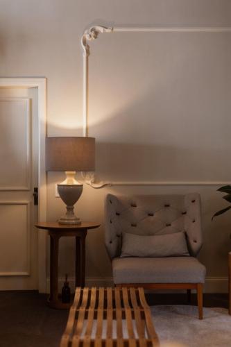 a room with a chair and a table with a lamp at Hotel Casacurta in Garibaldi