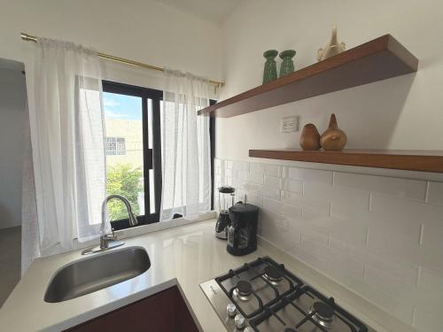 a kitchen with a sink and a stove and a window at Casa DOS21 Boutique Apartments Playa Sur in Mazatlán