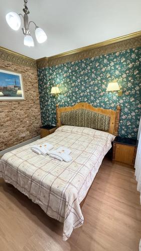 a bedroom with a large bed with floral wallpaper at Diplomat Hotel in Buenos Aires