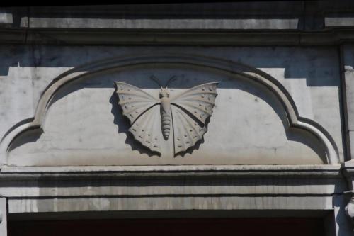 a butterfly sculpture on the side of a building at Les mésanges bleu in Malmedy