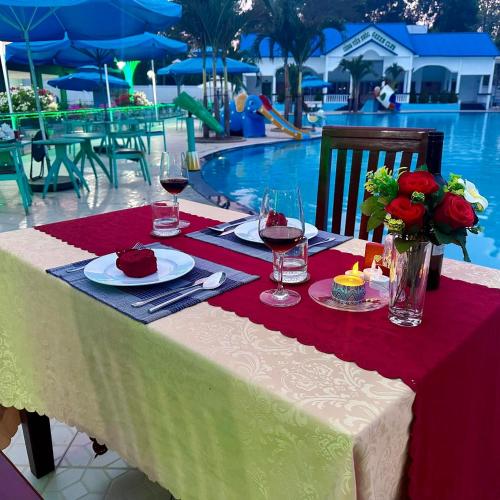 a table with wine glasses and food and flowers on it at HOMESTAY Hoàng GIa in Ấp Ông Tú