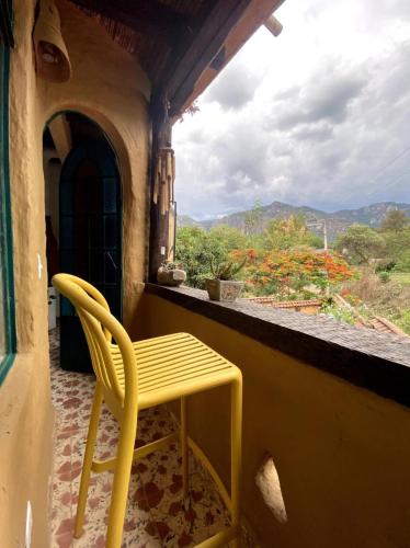 a yellow chair sitting on a balcony with a window at Casa Gaudí en Tepoztlán in Tepoztlán