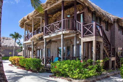 a resort building with a thatch roof at Villas De Isla Bonita in San Pedro