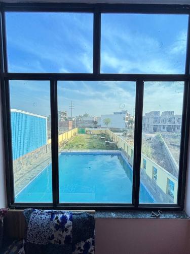a view of a swimming pool through a window at Midiyan Resort in Jaipur