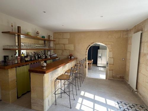 a kitchen with a bar with stools in a room at Au puits ancien in Grézillac