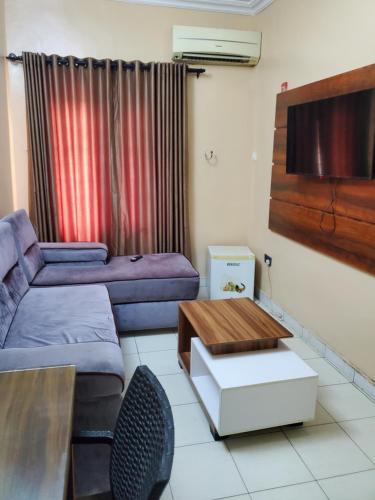 a living room with a couch and a table at Romeo Suites & Apartment in Ipaja