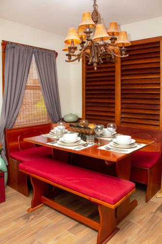 a dining room table with red cushioned chairs and a dining room at Villas De Isla Bonita in San Pedro