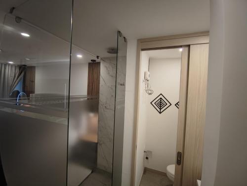 a bathroom with a glass shower and a toilet at Indigo 513 - Apartamento con Piscina, Gym, Parking, Ubicación 10 de 10 in Armenia
