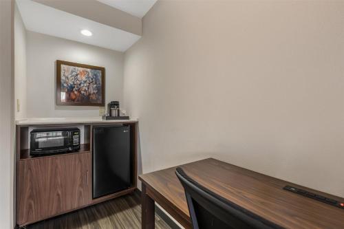 a room with a microwave and a wooden table at Best Western Plus Lexington Inn in Lexington