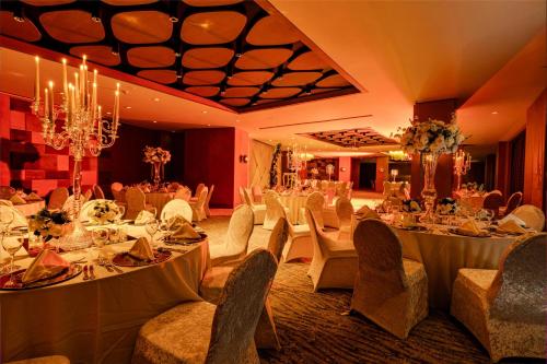 a banquet hall with white tables and chairs and a chandelier at Radisson Hotel Istanbul Merter in Istanbul