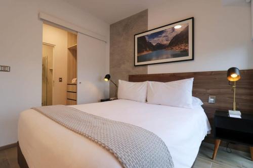 um quarto com uma grande cama branca em um quarto em The Modern by Wynwood House em Lima