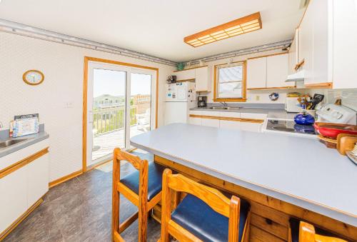 a kitchen with a counter and chairs in it at De-Duck-Tible - D0318 in Duck