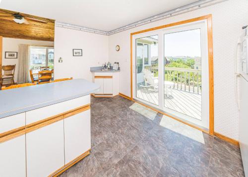 a kitchen with white cabinets and a large window at De-Duck-Tible - D0318 in Duck