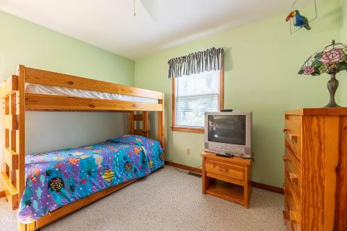 a bedroom with a bunk bed and a television at De-Duck-Tible - D0318 in Duck