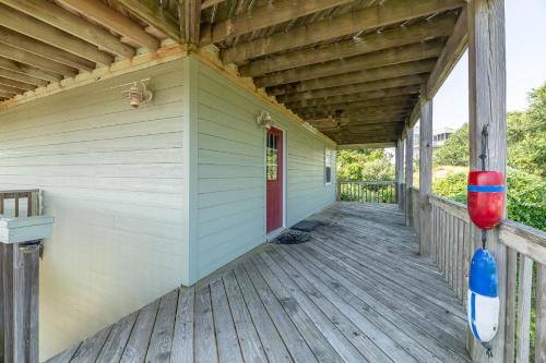a porch of a wooden house with a red door at De-Duck-Tible - D0318 in Duck