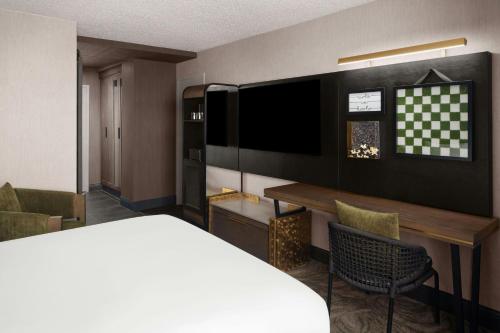 a hotel room with a bed and a desk and a television at Renaissance Chicago North Shore Hotel in Northbrook