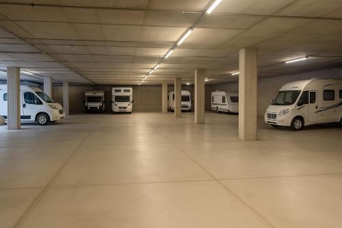 a parking garage with several white vans parked in it at Hotel Garda in Affi