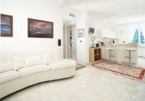 a living room with a white couch and a kitchen at Casa di Alex in Genova
