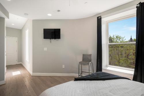 a bedroom with a bed and a tv on the wall at The Castle in Washington, D.C.