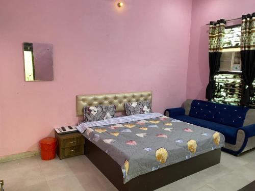 a bedroom with a bed and a blue couch at Hotel Hansi in Hānsi