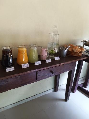 a wooden table with jars of different colored liquids at Pousada Rota in Paty do Alferes