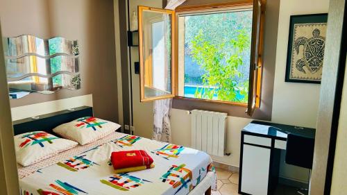 a small bedroom with a bed and a window at à l'ombre de l'olivier in Saint-Jean-de-Fos