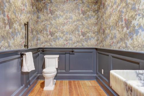 a bathroom with a toilet and a wallpaper at The 200 South St - King Rm 21 in Charlottesville