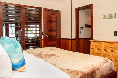 a bedroom with a bed and a dresser and a window at Villas De Isla Bonita in San Pedro