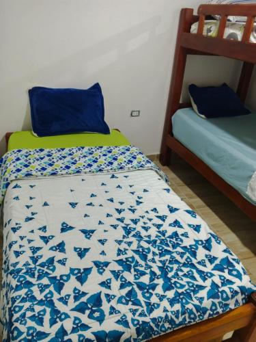 a bedroom with a bed with a blue and white quilt at Kasa Soffi in Moñitos
