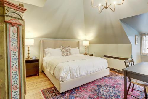 a bedroom with a bed and a table and a desk at The 200 South St - King Rm 11 in Charlottesville