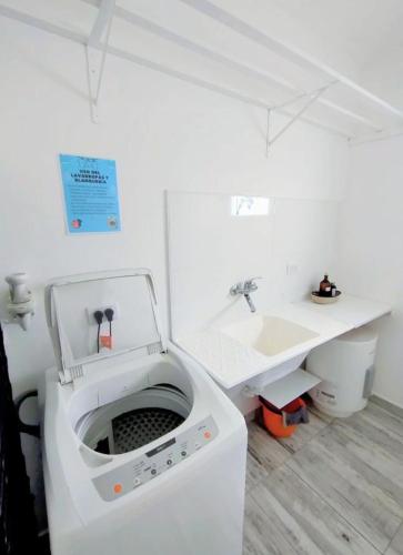 a white washing machine in a bathroom with a sink at Casa con jardín Las Marías 1 in Miramar