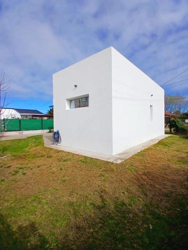 a white building on top of a grass field at Casa con jardín Las Marías 1 in Miramar