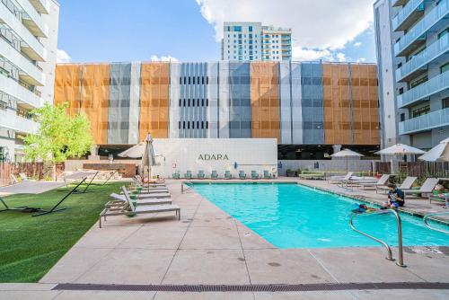 a swimming pool with chairs and a building at Charming 2BD - Central Downtown - Gym, Pool, Parking in Phoenix