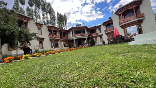 a large building with a lawn in front of it at Mandalchan hotel in Leh