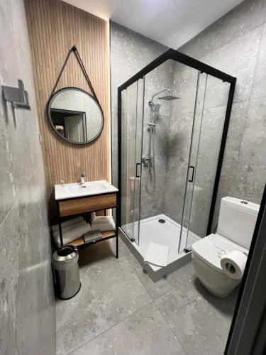 a bathroom with a shower and a toilet and a sink at Hotel SYLWANA in Białe Błota