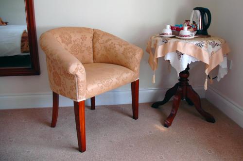 a room with a chair and a table with a mirror at The Down Inn in Bridgnorth